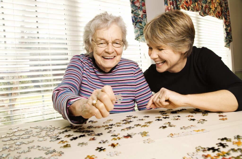 A senior and their adult child work together on a jigsaw puzzle to help improve working memory after a dementia diagnosis.